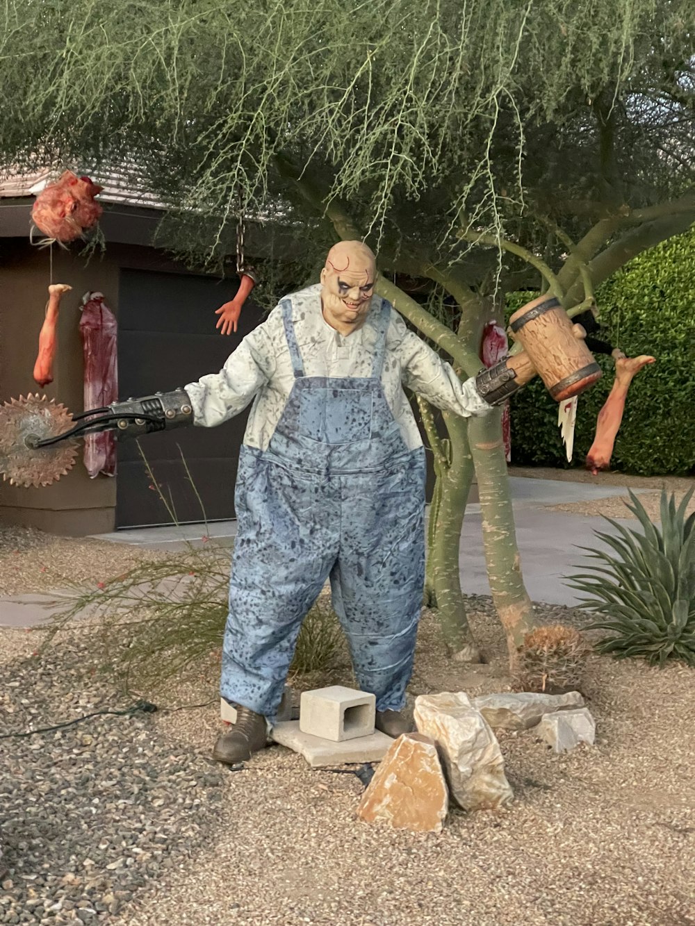 a statue of a man holding two buckets in front of a tree