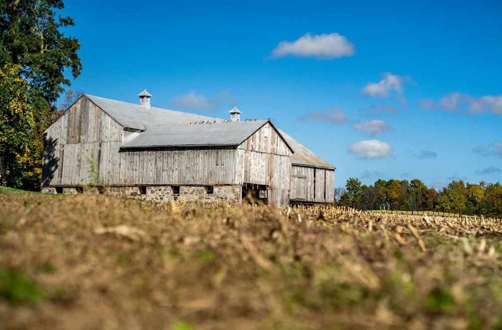 a barn in a field with a blue sky in the background