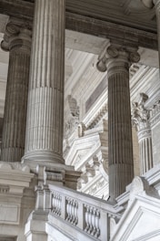 a building with columns and a clock on the side of it