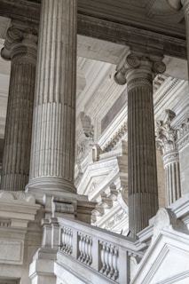 a building with columns and a clock on the side of it