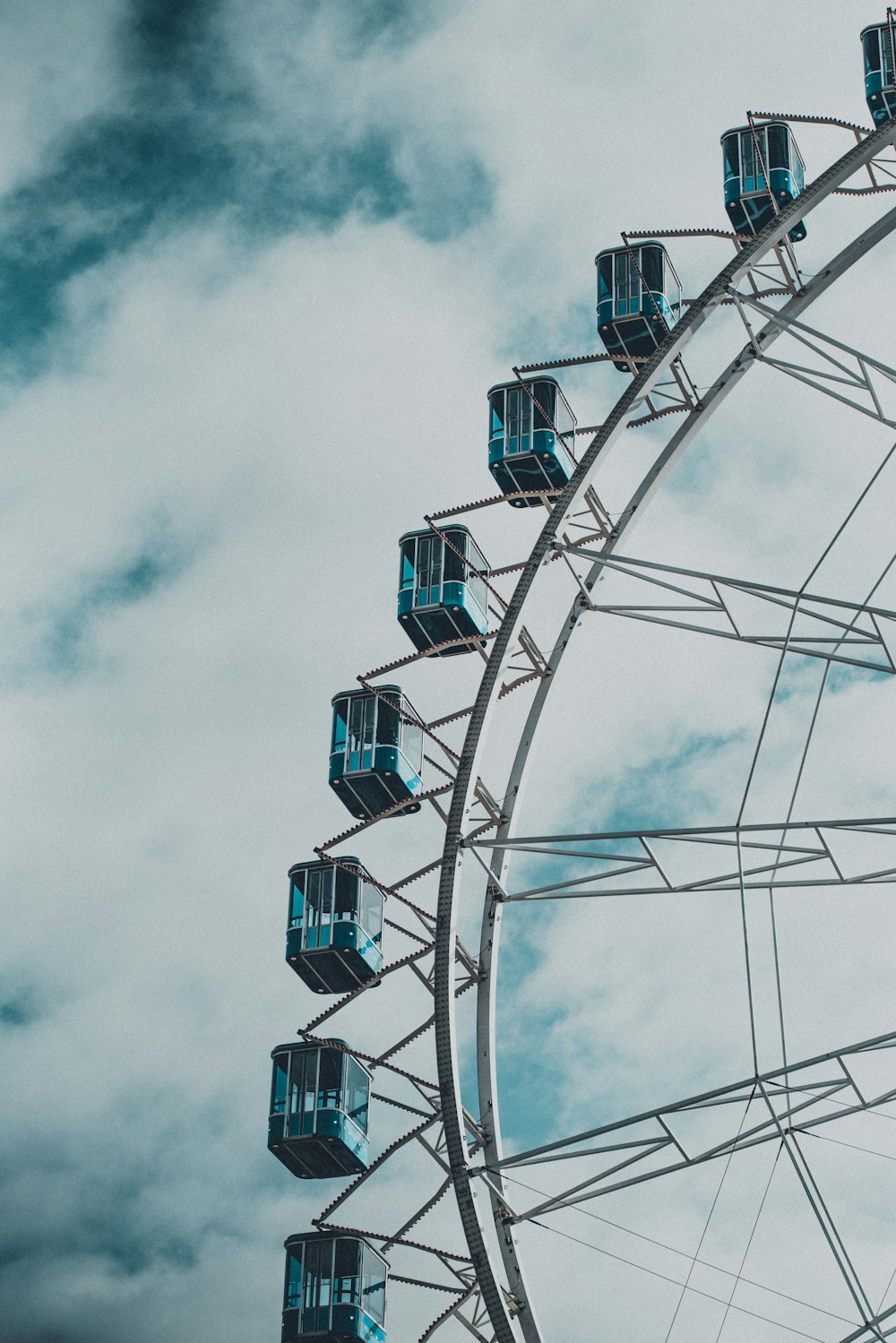 a ferris wheel with blue windows on a cloudy day