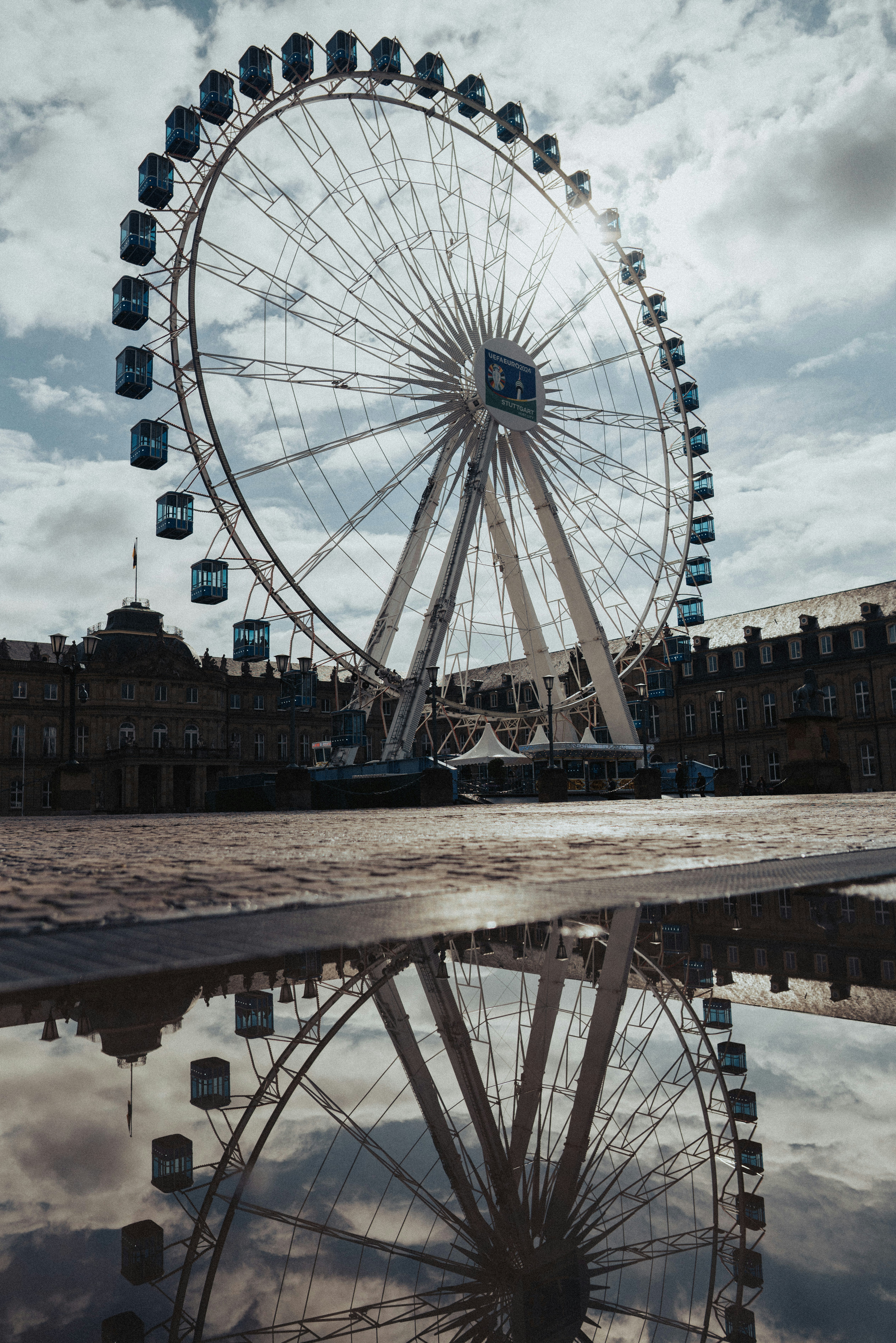 una grande ruota panoramica seduta accanto a uno specchio d'acqua