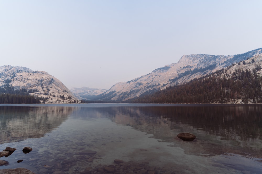 a lake surrounded by snow covered mountains and trees