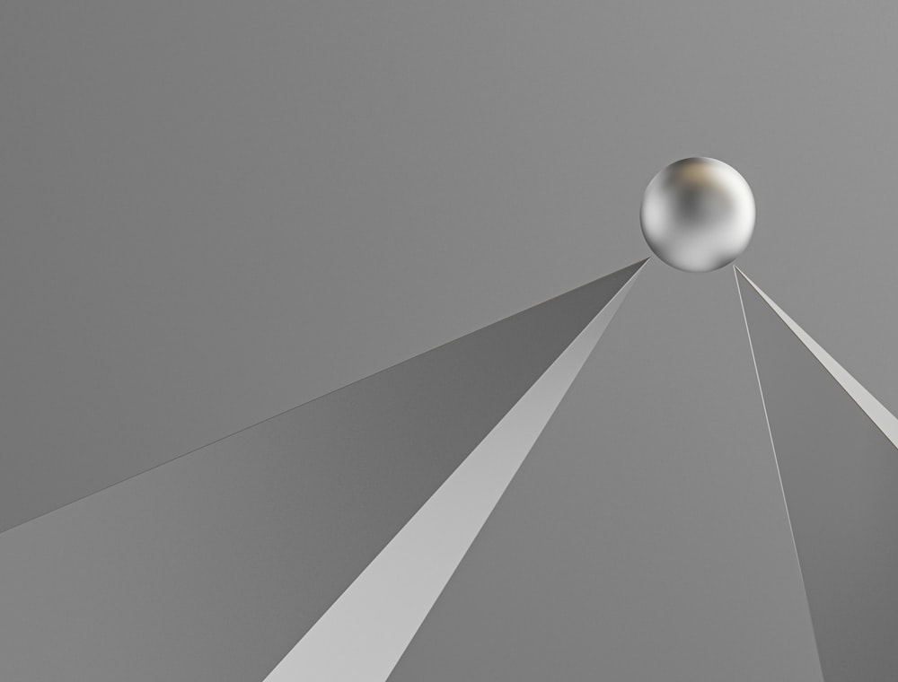 uma imagem abstrata de uma bola de prata no ar