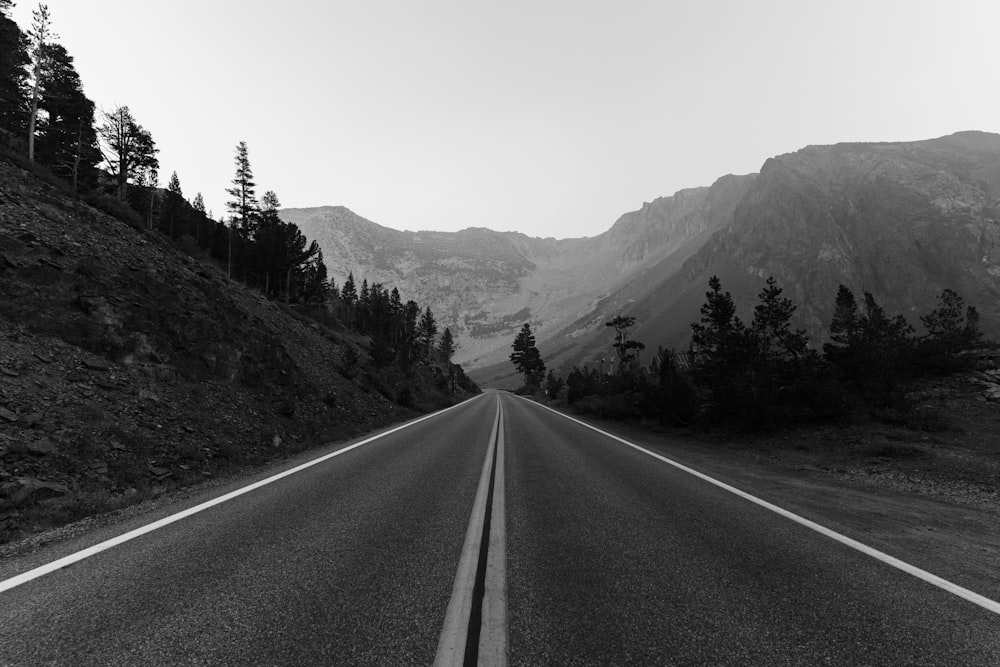 a black and white photo of a road in the mountains