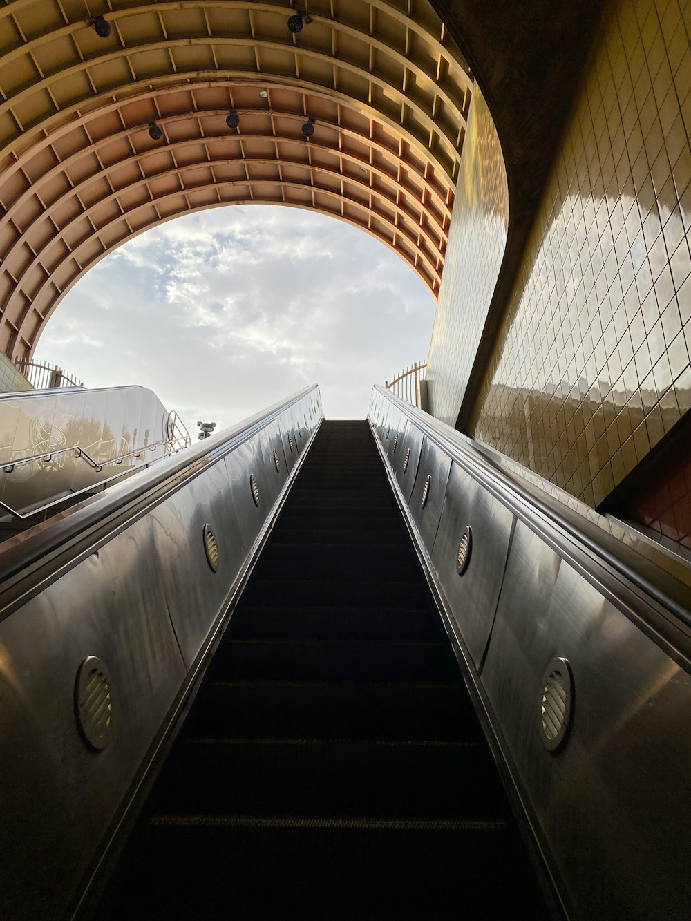 an escalator in a building with a sky background