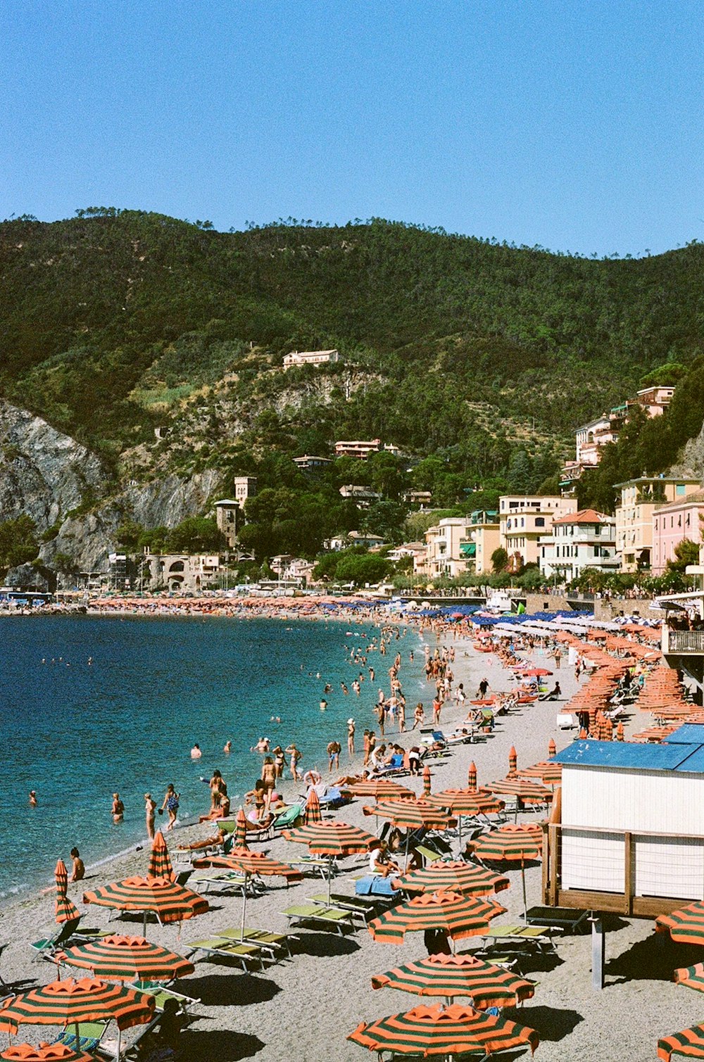 a beach filled with lots of people and umbrellas