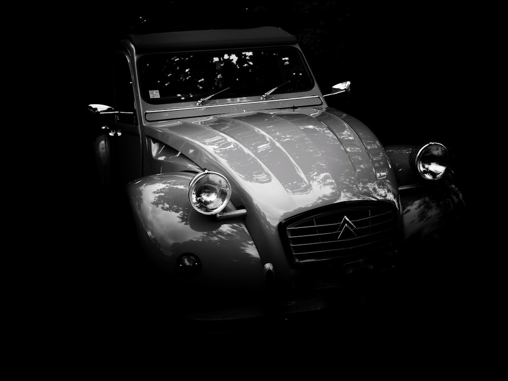 a black and white photo of a car in the dark