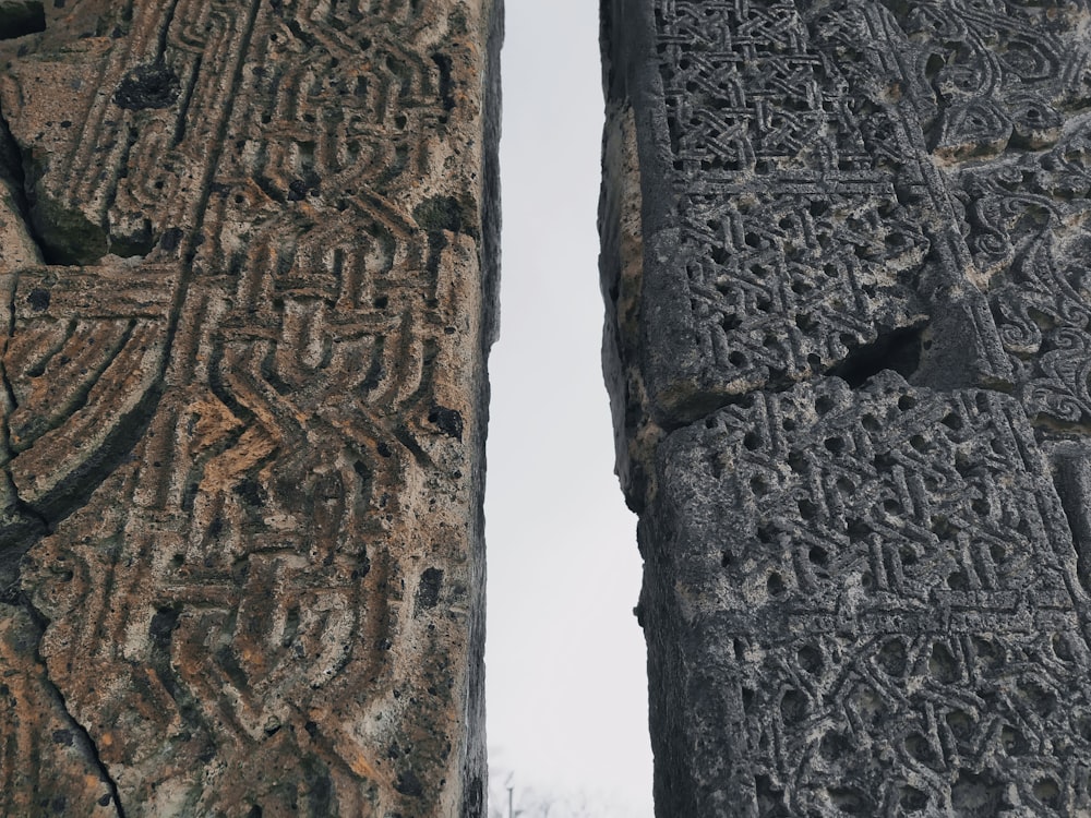 duas esculturas em pedra com escrita sobre elas