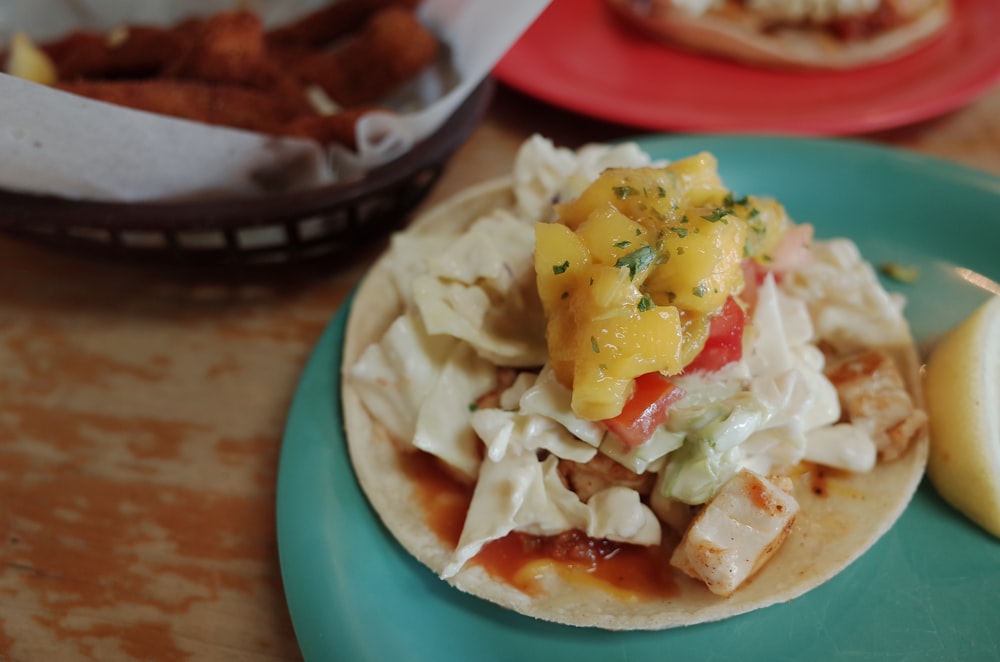 a plate of food on a table next to a basket of fries