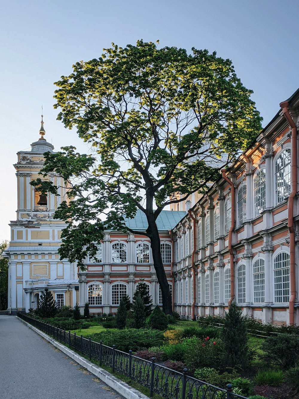 a large building with a clock tower next to a tree