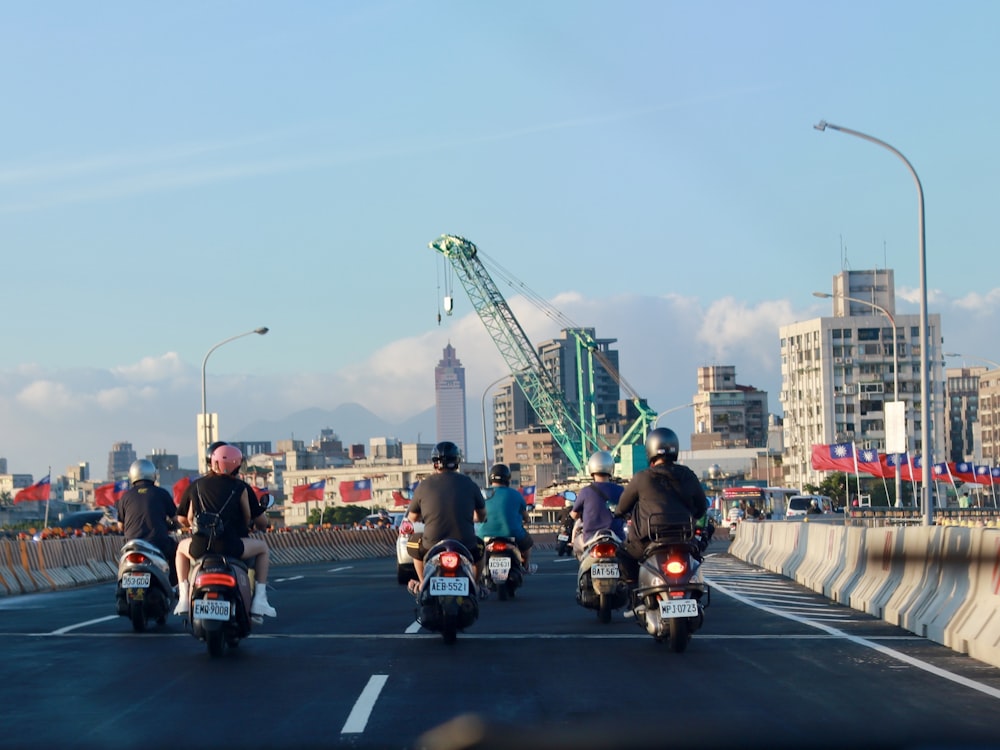 a group of people riding motorcycles down a street