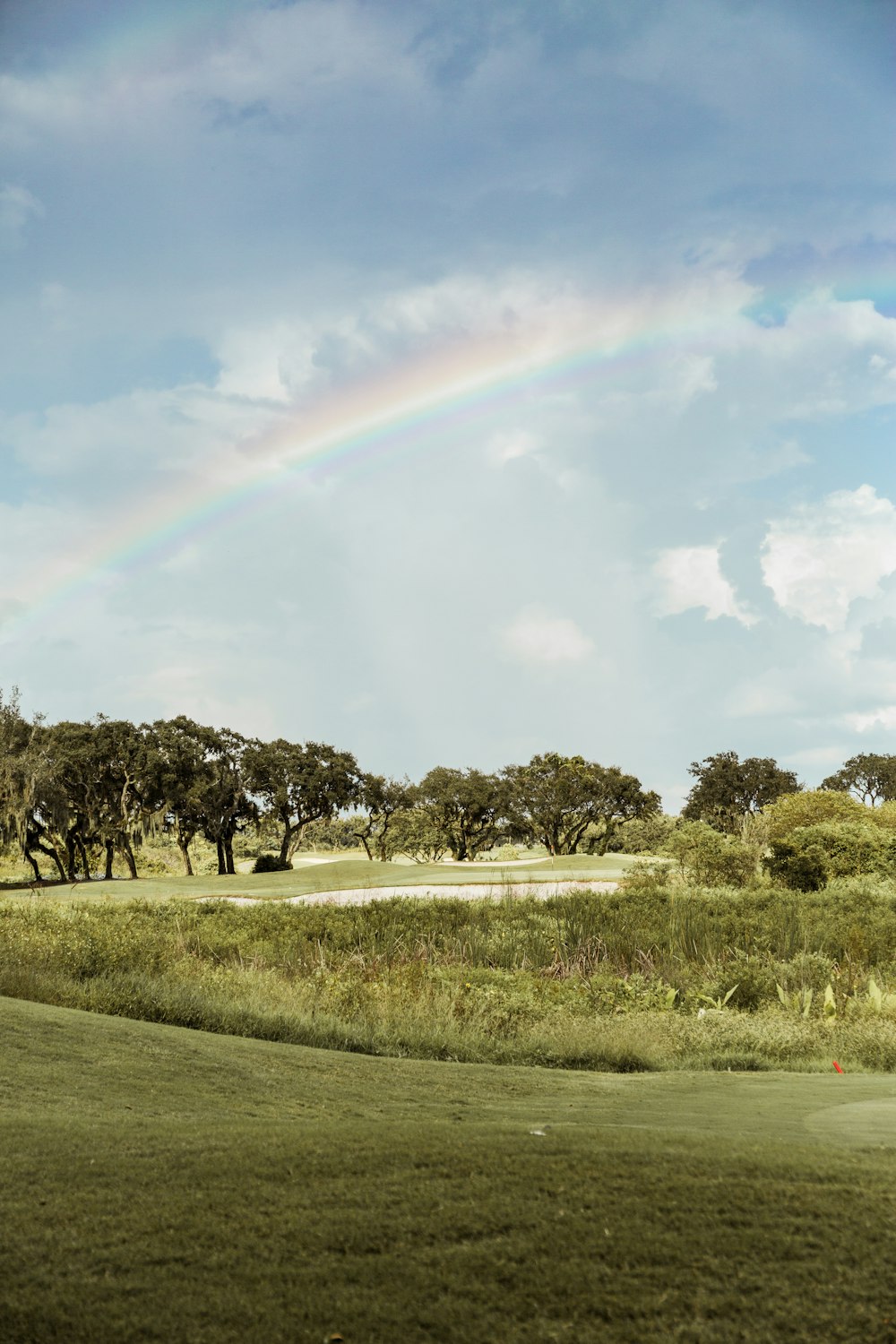 Ein Regenbogen am Himmel über einem Golfplatz