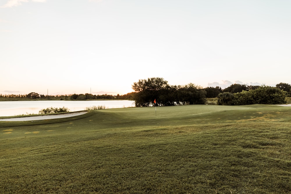 a golf course with a lake in the background