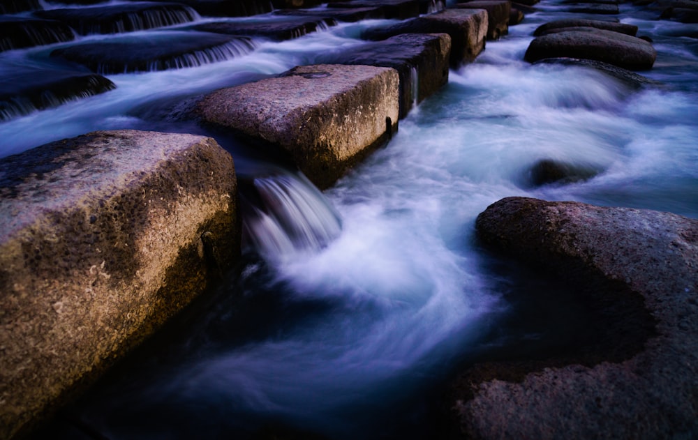 a long exposure photo of a river flowing over rocks