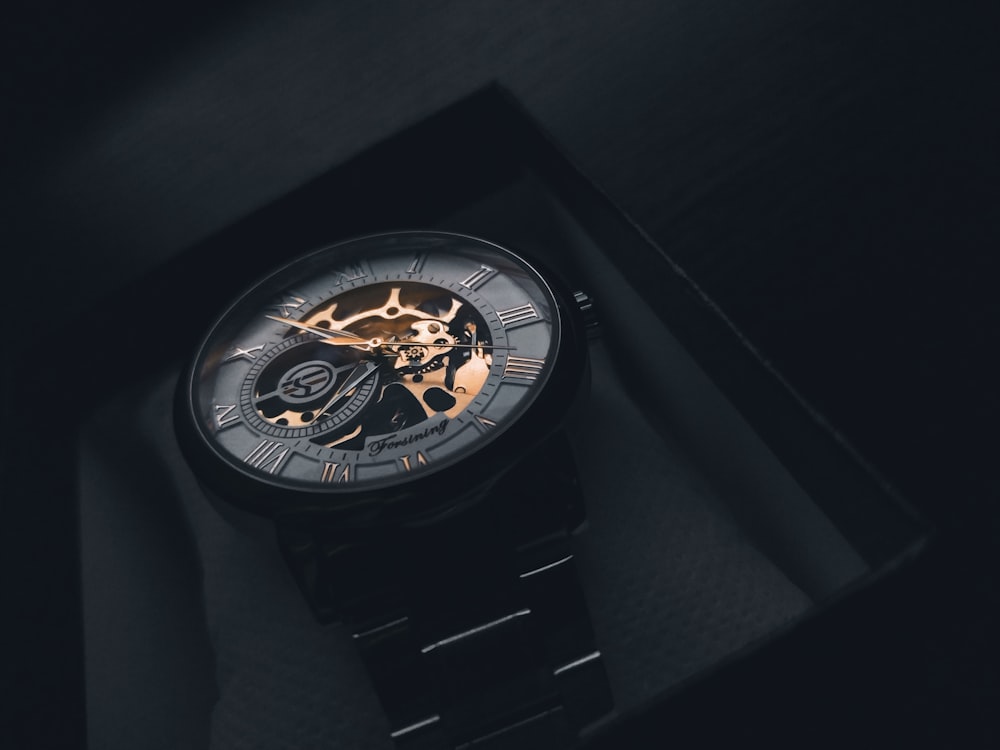 une montre posée sur une boîte noire