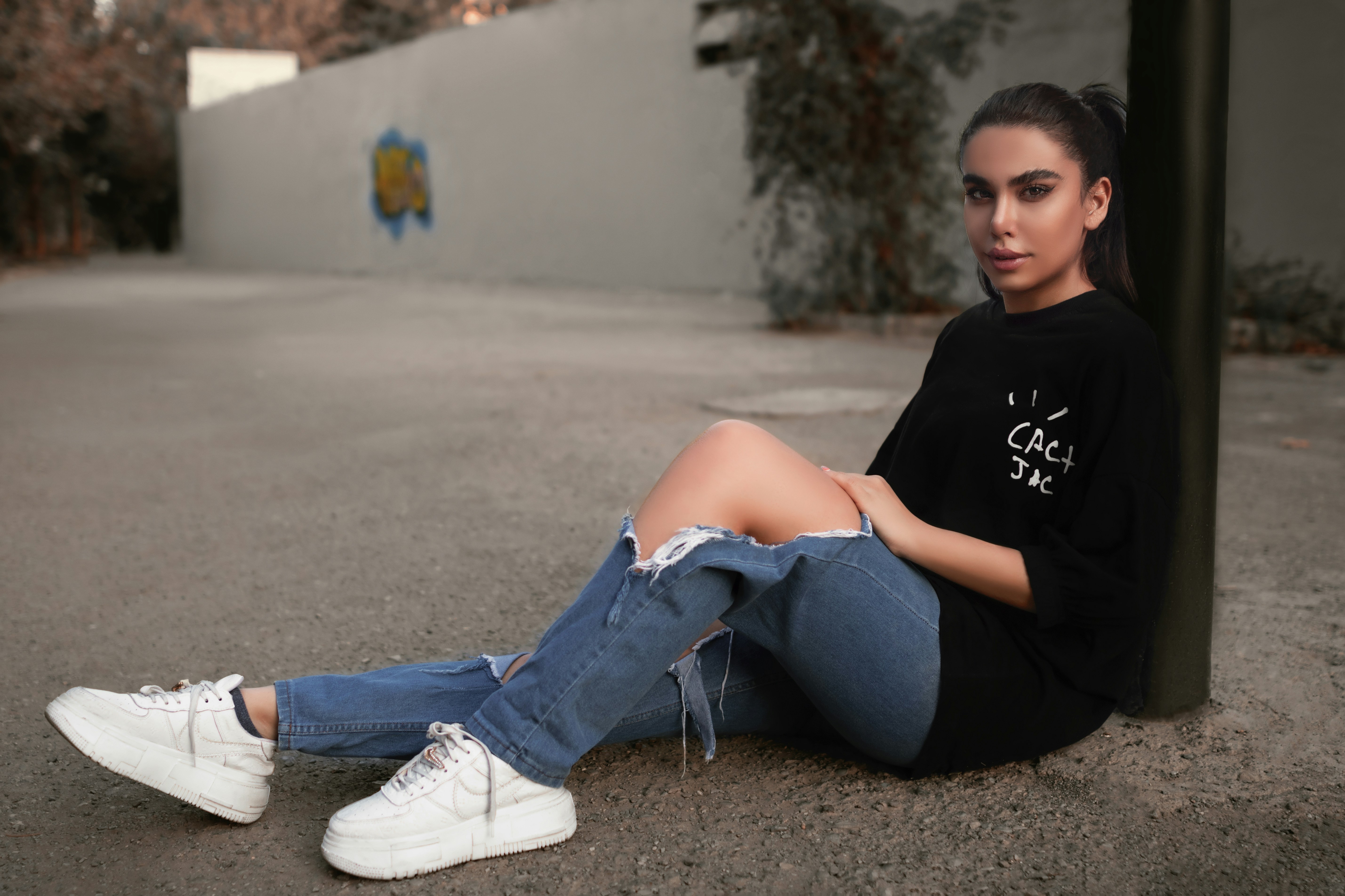 a woman sitting on the ground with her legs crossed
