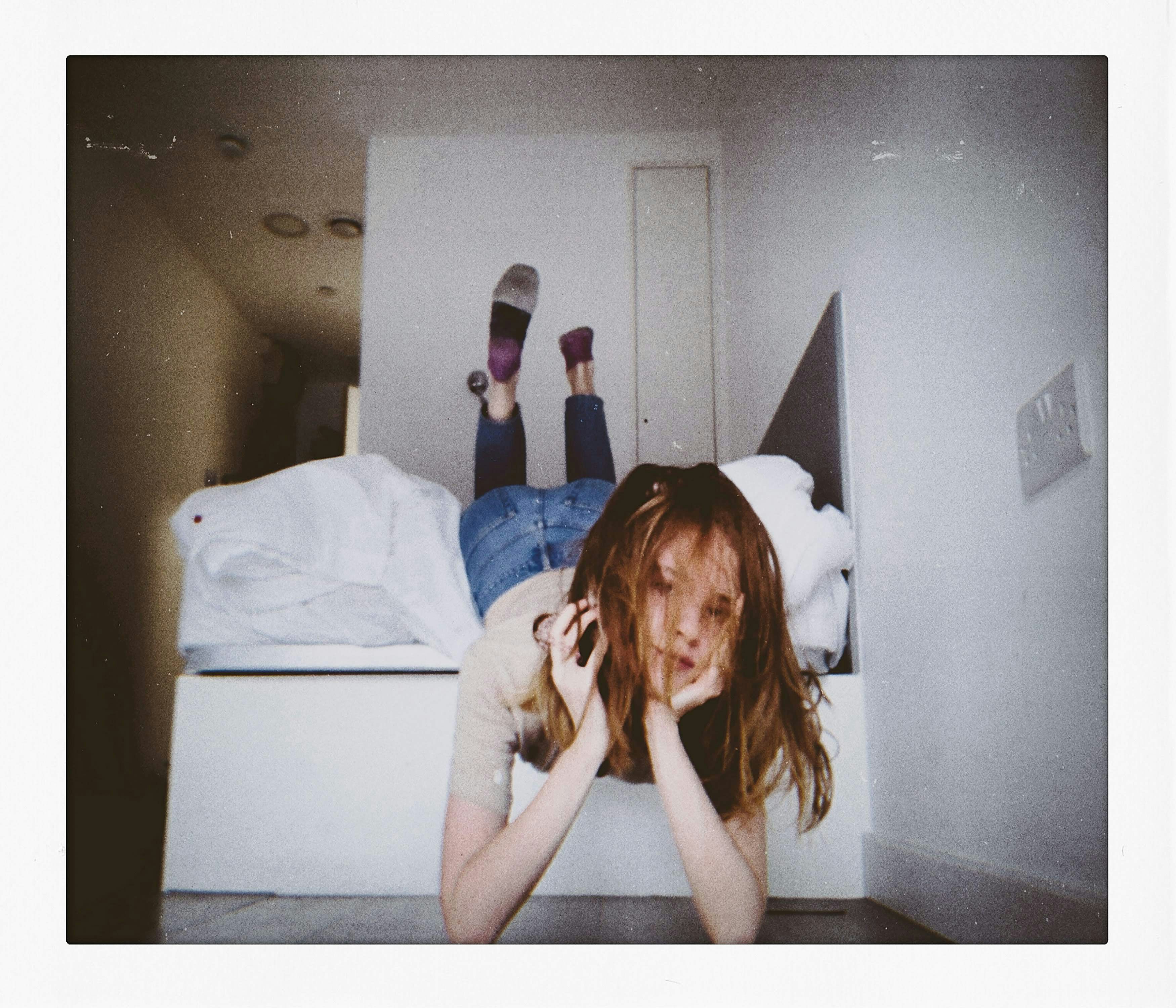 a woman laying on a bed with her feet up