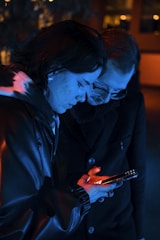 A tense moment between two characters in a suspenseful vertical drama, framed tightly on a smartphone screen.