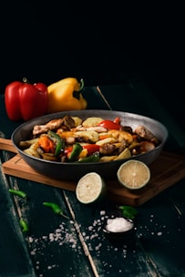 a pan filled with food sitting on top of a wooden cutting board