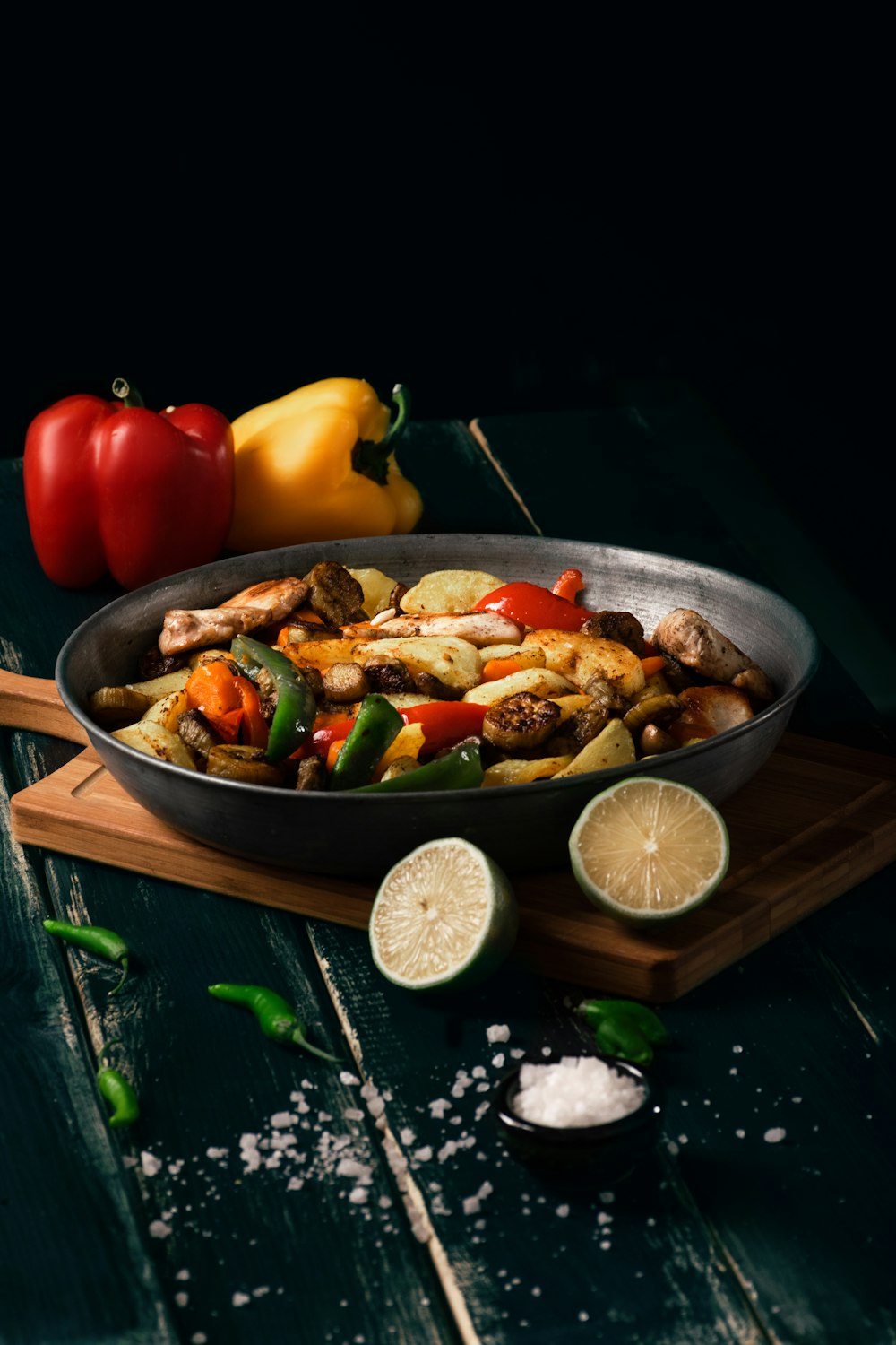 a pan filled with food sitting on top of a wooden cutting board