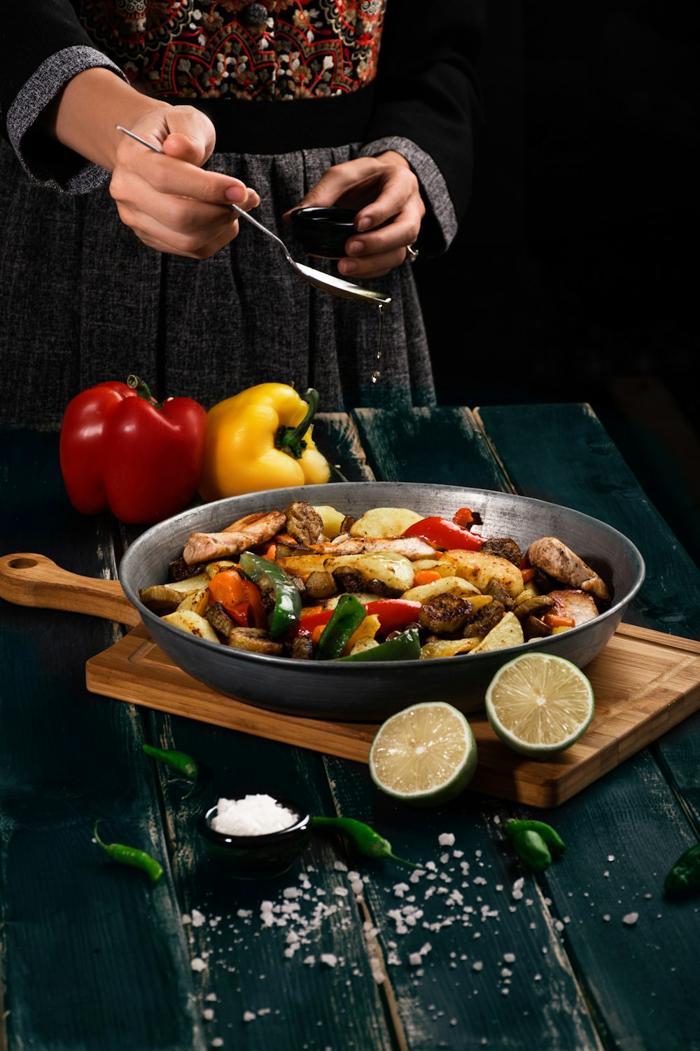 a woman in a black dress is preparing a meal