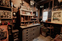 A cozy workspace featuring shelves filled with retro computer parts and antique collectibles.