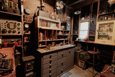 A cozy workspace featuring shelves filled with retro computer parts and antique collectibles.