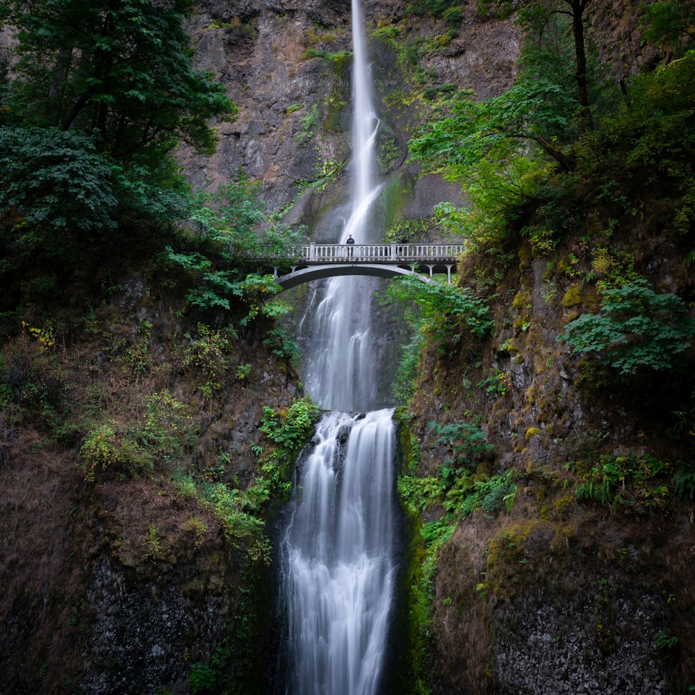 a large waterfall with a bridge over it