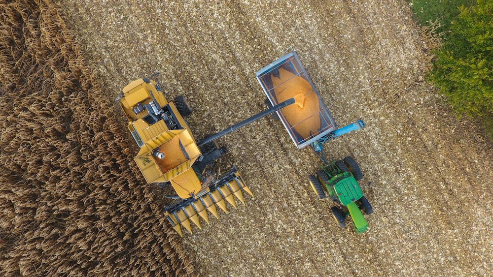 an aerial view of a tractor and a combine in a field