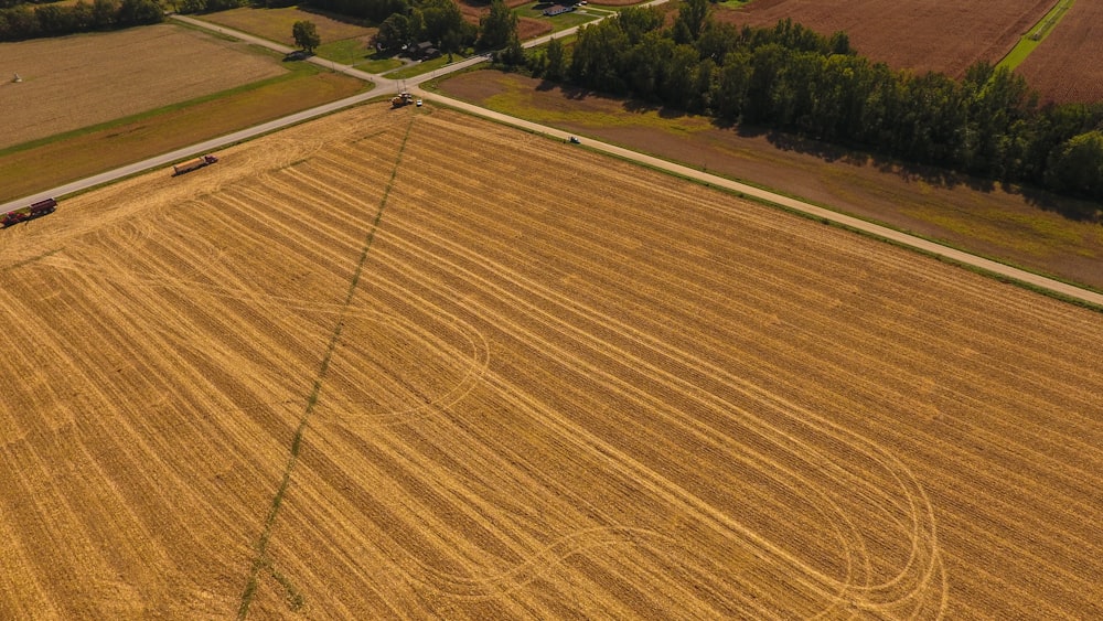 an aerial view of a farm field with a tractor and a tractor trailer