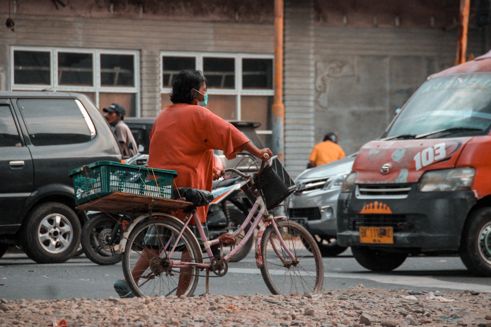 a man riding a bike down a street next to parked cars