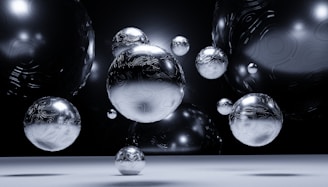 Several reflective, metallic spheres with intricate patterns float in a dark, ambient space. The composition displays a futuristic and abstract aesthetic, with the spheres creating an illusion of depth and dimension.