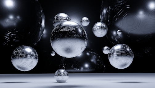 Several reflective, metallic spheres with intricate patterns float in a dark, ambient space. The composition displays a futuristic and abstract aesthetic, with the spheres creating an illusion of depth and dimension.