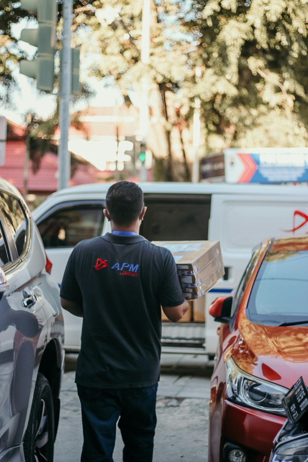 Un hombre caminando por una calle junto a autos estacionados