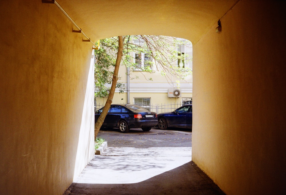 a narrow alley way with cars parked on both sides