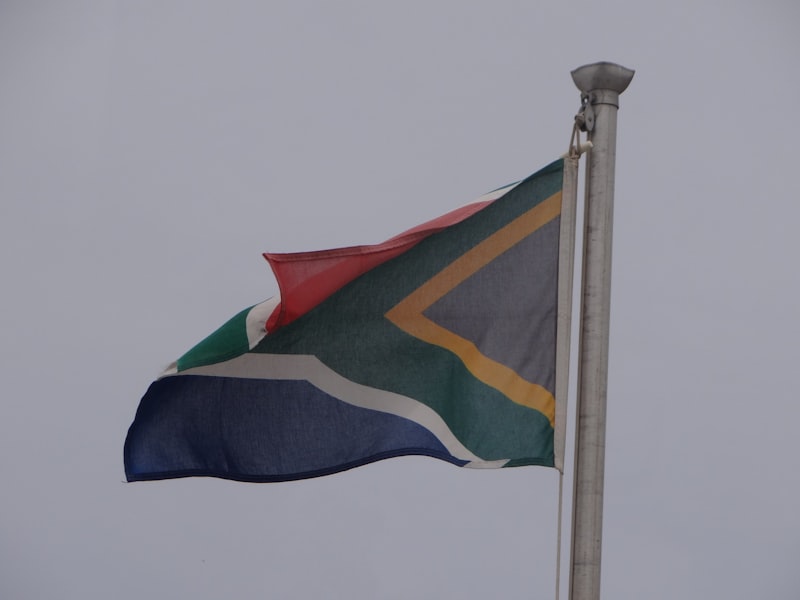 South African flag flying on a flagpole against a grey sky