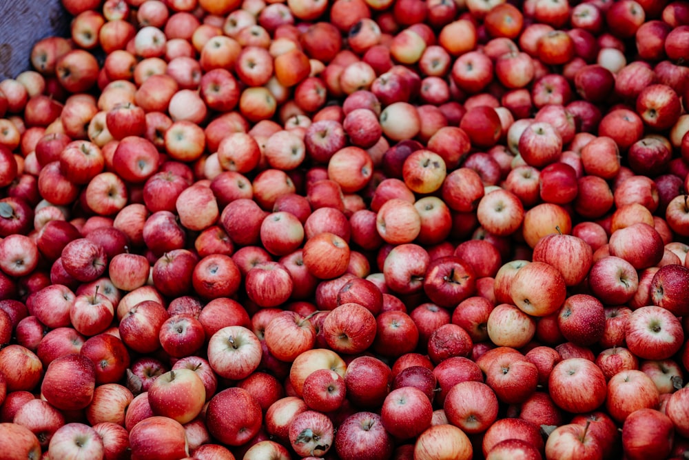 a pile of red apples sitting on top of each other