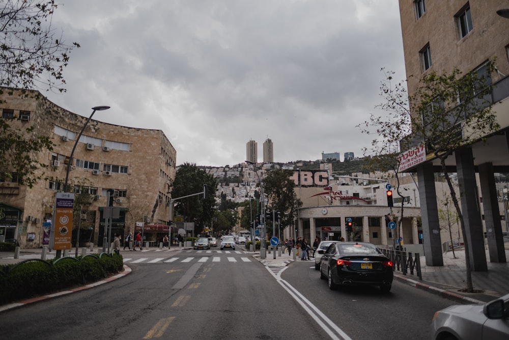 a car driving down a street next to tall buildings