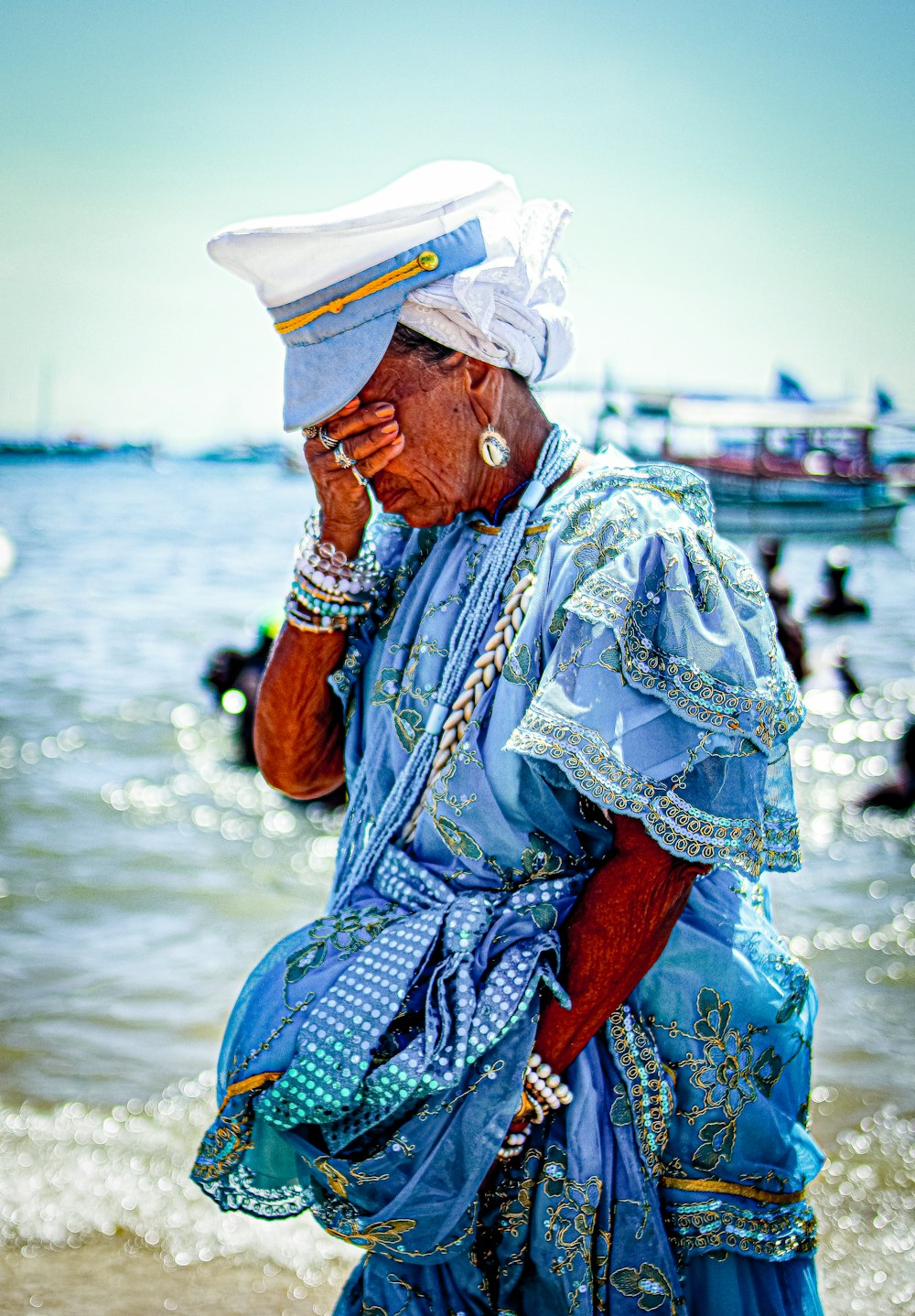 a woman in a blue dress standing on a beach