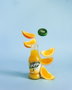 a bottle of jaffa orange juice falling into the air