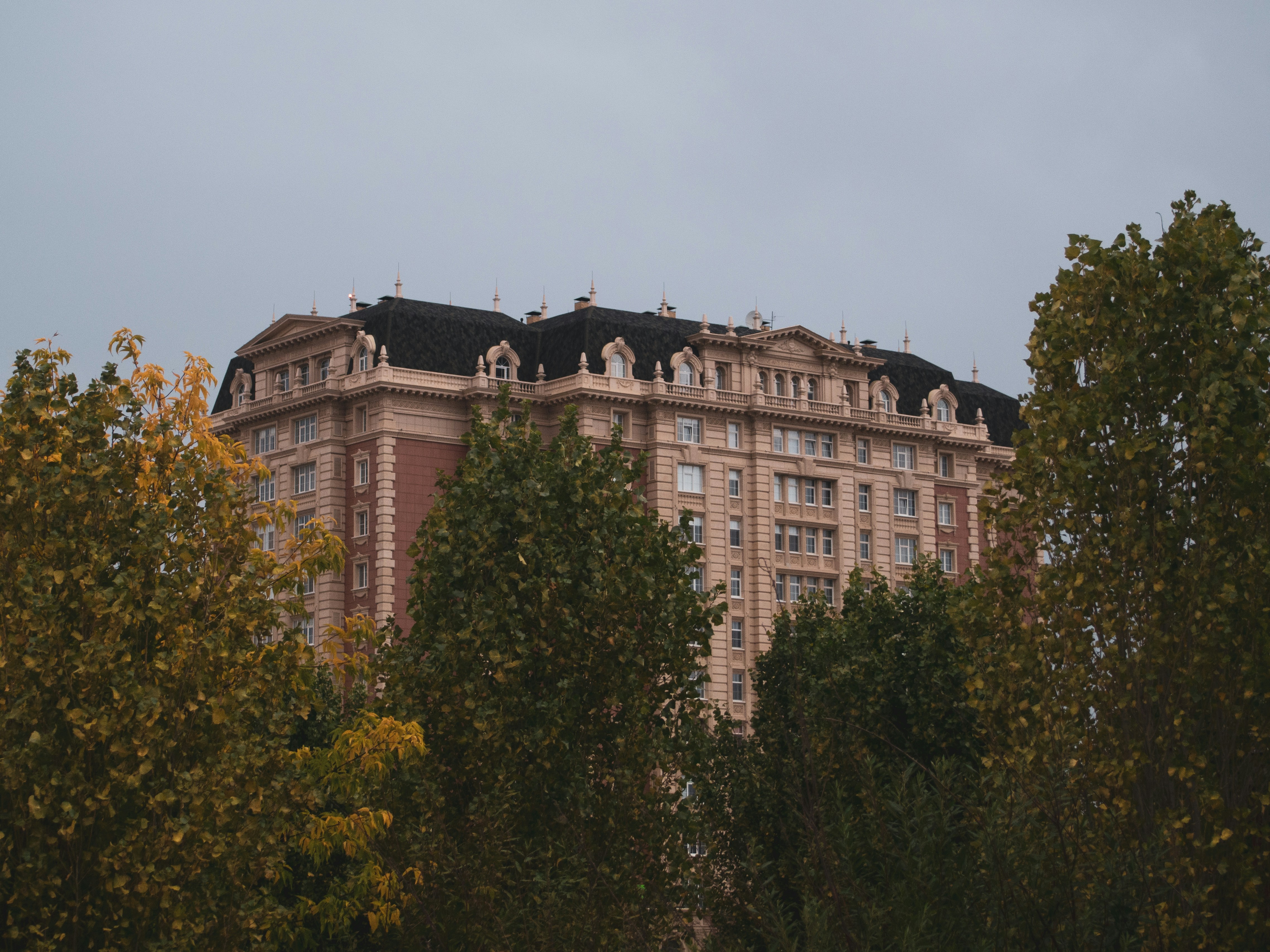 A large building surrounded by trees on a cloudy day
