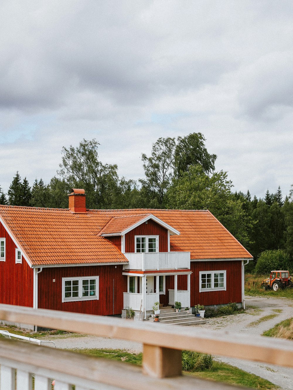 Una casa roja con techo rojo y adornos blancos