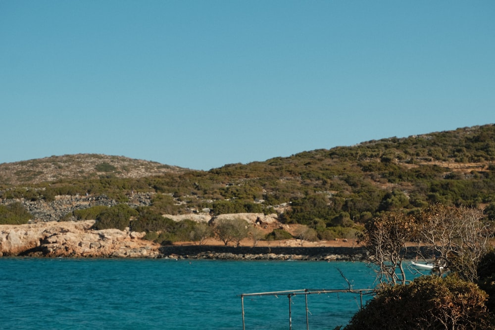 a body of water with a hill in the background