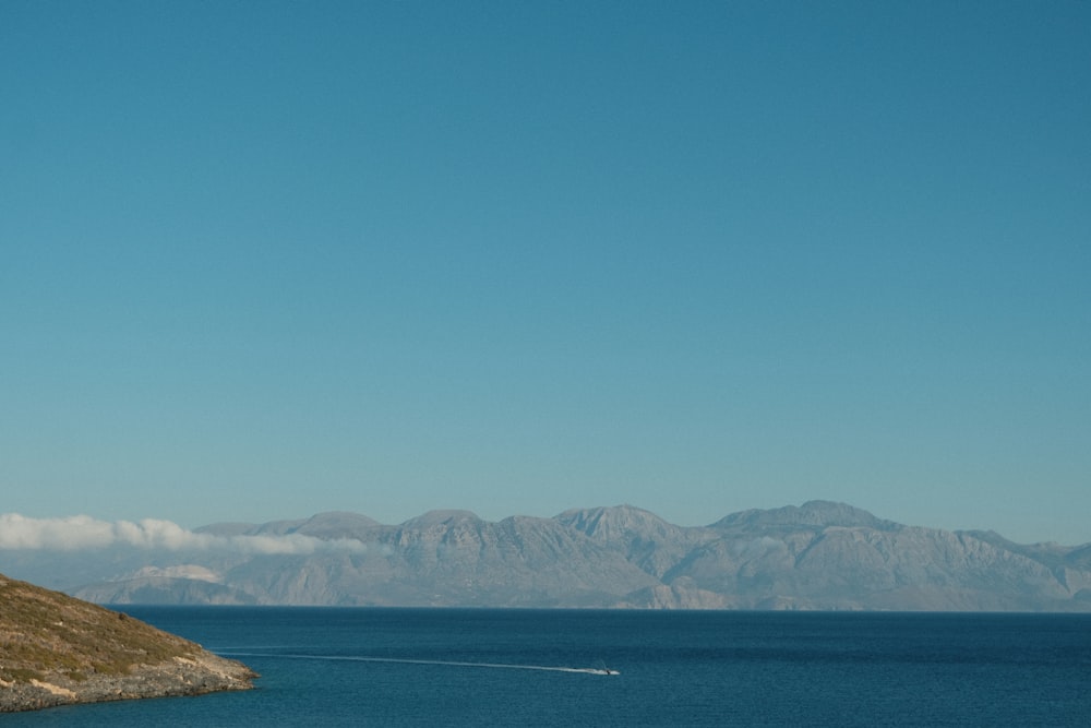 a boat is out on the water near a hill