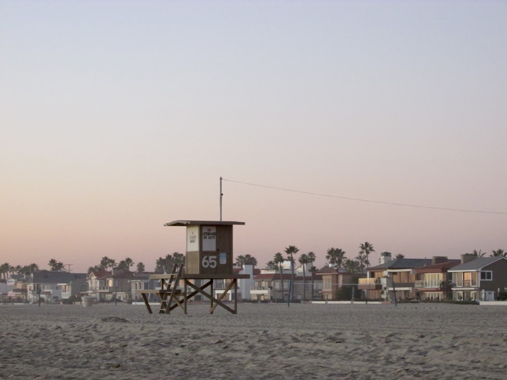 a lifeguard tower on the beach with houses in the background