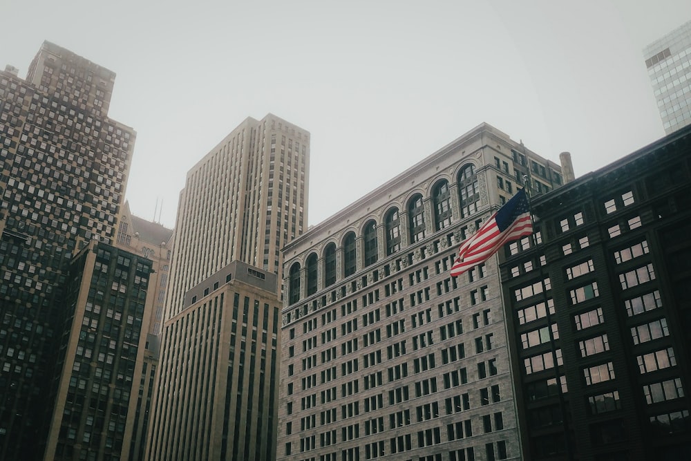 Una bandera estadounidense ondeando frente a un gran edificio