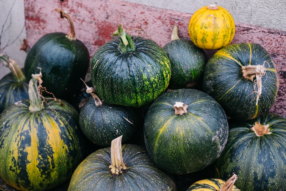 a pile of green and yellow pumpkins sitting next to each other