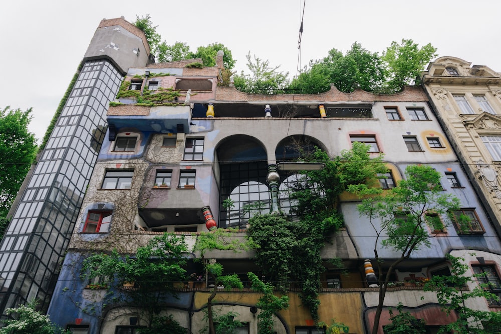 a very tall building with lots of windows and plants growing on it