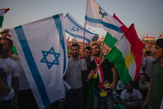 a group of people holding flags in front of a crowd